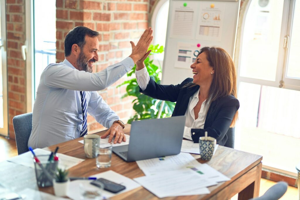 Geschäftspartner geben sich ein High-Five im Büro