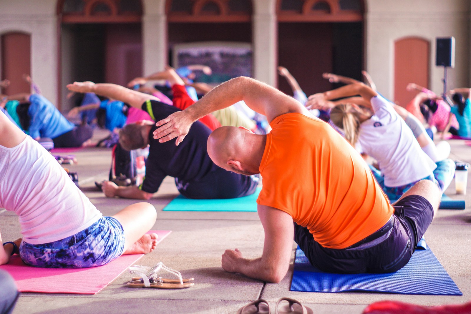 Menschen in einer Gruppen-Yoga-Stunde, die Dehnübungen machen